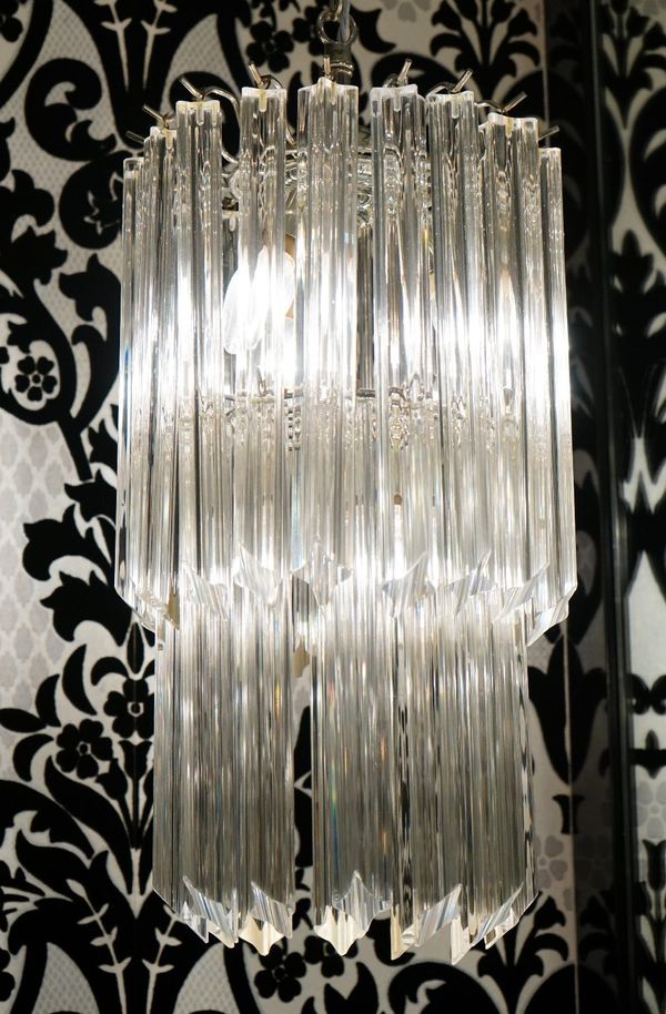 A pair of glass pendant light fittings, with four bulbs, hung with two tiers of concave sided glass drops (2).40cm high