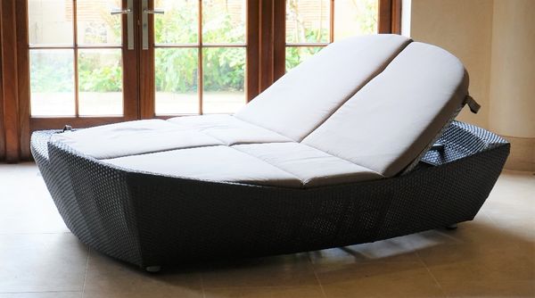 A grey woven day bed lounger for two persons, with adjustable back and footrests and loose cushions.230cm wide x 145 high