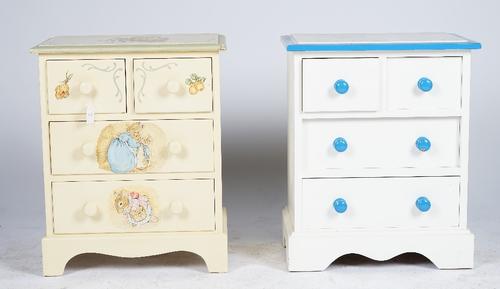 A child's white and blue painted chest of four drawers, another painted with Beatrix Potter figures, a white painted three drawer dressing table and a
