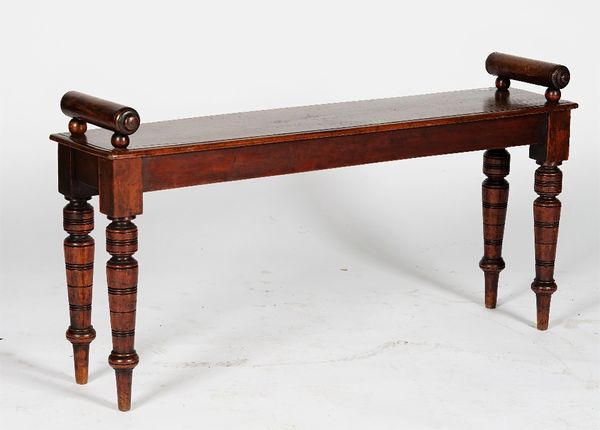 An Edwardian walnut hall bench, with roll arms, on turned legs, 101cm wide x 45cm high.