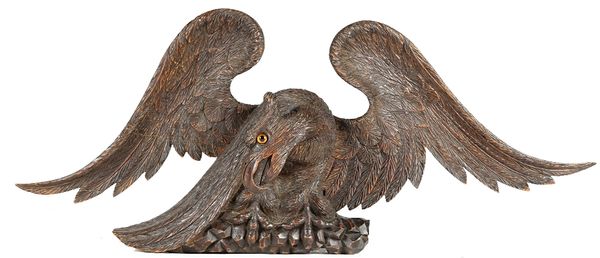 A carved pine surmount, in the form of an eagle perched on rock work, 19th century.