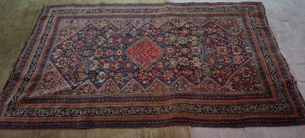 A Persian rug, with a central emblem surrounded by a border of repeated design, 235cm x 140cm.