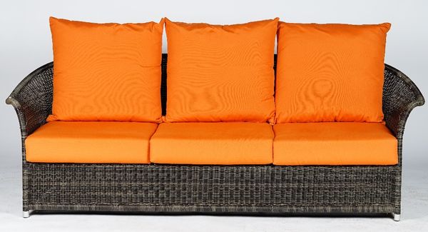 A four piece woven wicker loggia suite, the loose back and seat cushions in orange fabric, the circular low table with plate glass top, chair; 86cm wi