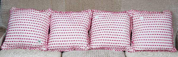 A set of four cushions, in pink and white with fuzzy applications (4).