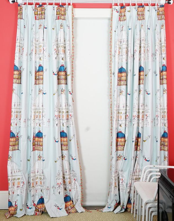 A pair of curtains, printed with Parisian scenes, with long bobble tassels. 85cm wide x 300cm long.