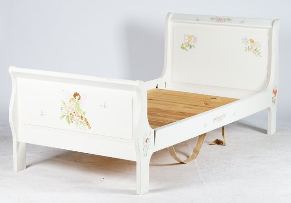 A child's sleigh bed, painted with fairies on a white ground, a matching chest of four drawers and a set of wall hanging shelves, the chest 85cm wide