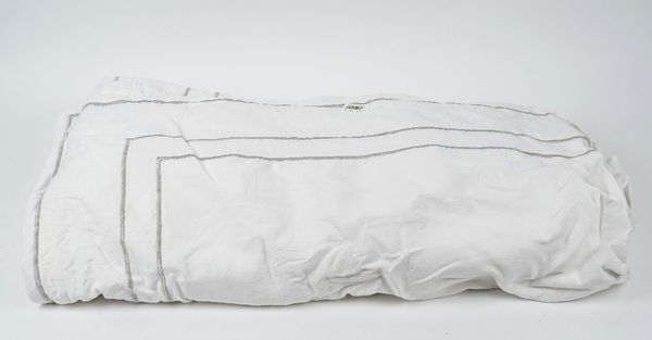 A large white linen table cloth with silvered thread borders.