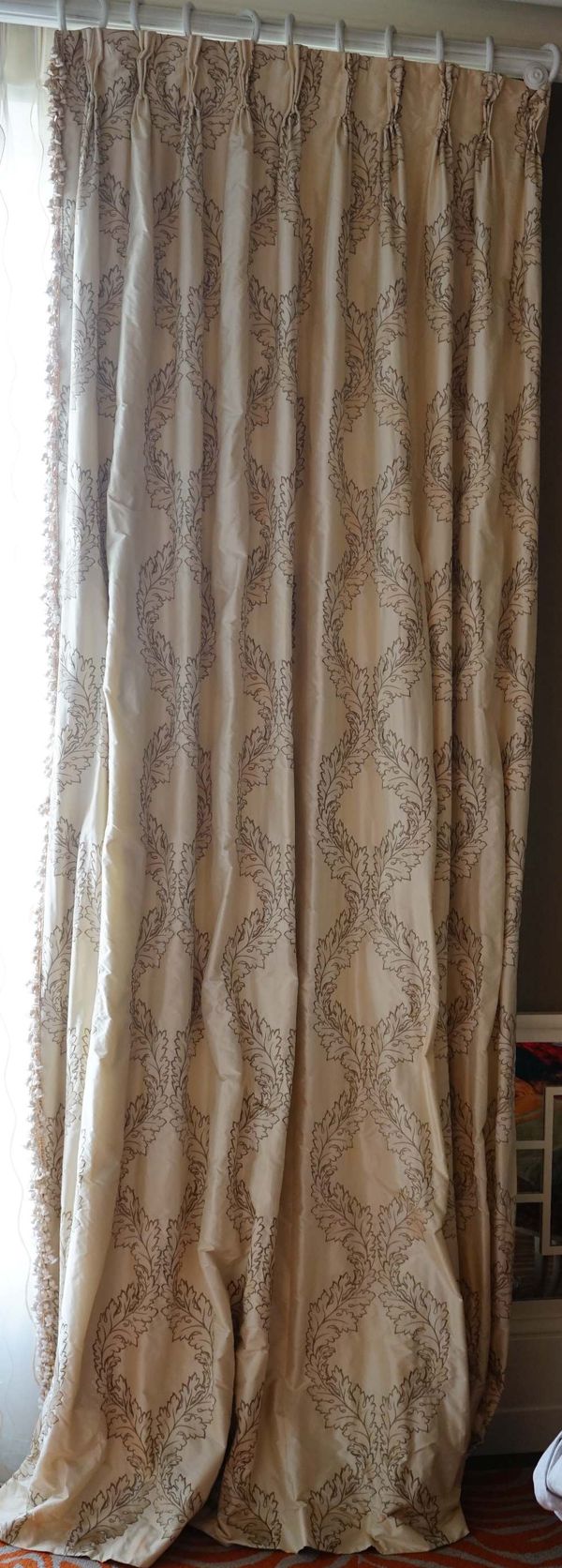 A pair of acanthus pattern cream silk curtains with onion tassel fringes. 125cm wide x 310cm long.