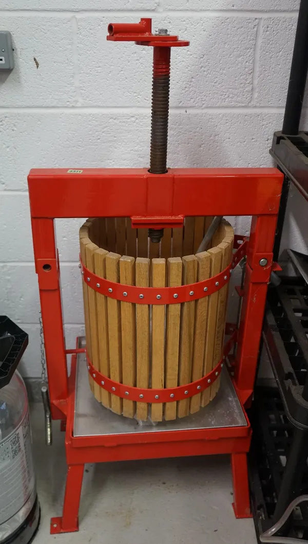 A red metal frame and wooden apple press and a Ballihoo Pressure Barrell and other items.