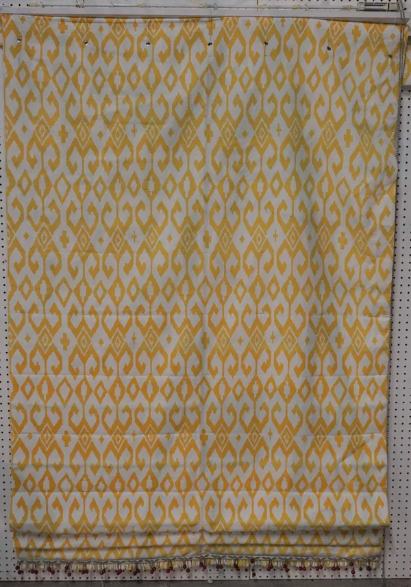 A set of three matching Roman blinds, with a repeated yellow design, on a white ground, with red bobble tassels (3). 130cm wide x 205cm long.