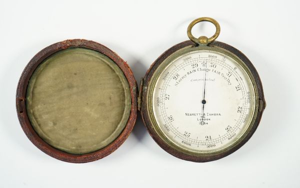 A Negretti & Zambra brass cased compensated barometer, early 20th century, with leather bound circular travel case, 7cm diameter.