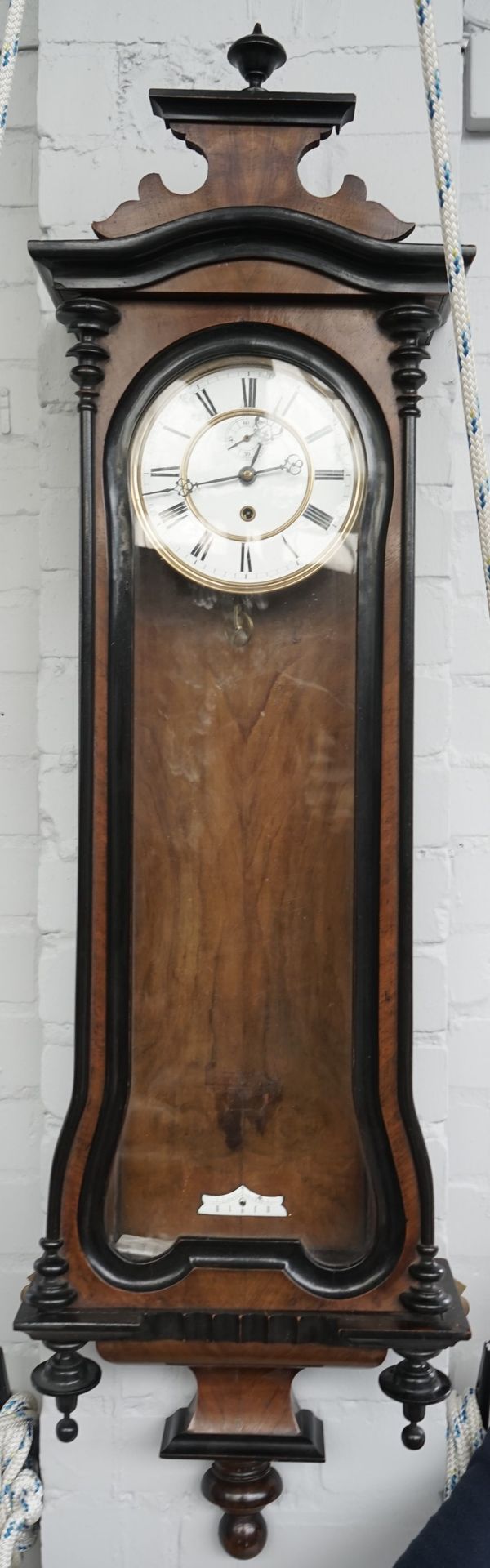 A Vienna regulator wall clock, 20th century, the enamelled tin dial with subsidiary seconds dial in a shaped glazed walnut case, 120cm high, (pendulum