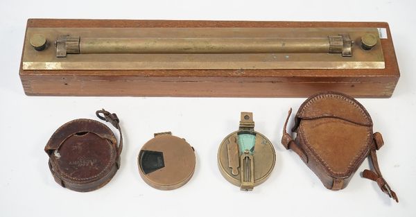 A brass rolling rule by W.H. Harling, London in a mahogany case, 46.5cm wide, a Short & Mason brass pocket clinometer and another brass cased clinomet