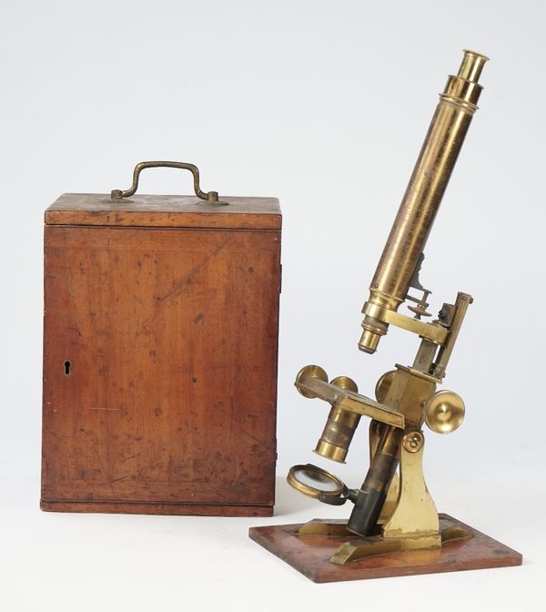 A Hudson & Sons gilt brass microscope, late 19th century, with rack and pinion focusing and fine adjustment in a mahogany fitted case.