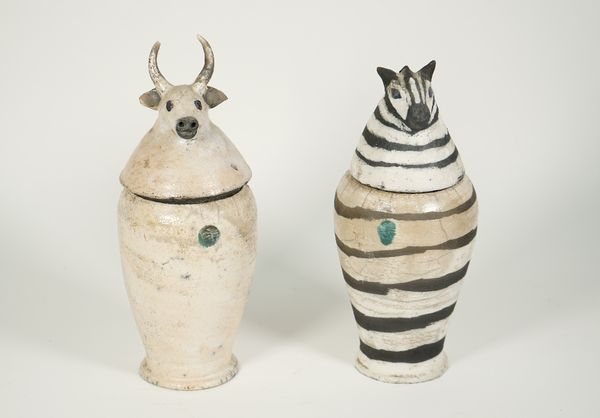 Two Charlotte Cadzow Amalie pottery jars and covers, one depicting a zebra, the other a bull, (31cm high), (2). ARR