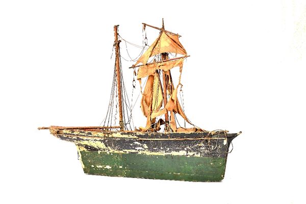 A large topsail schooner pond yacht, English, 19th century with twin masts, set of sails, (distressed) and a painted planked wooden hull, 152cm wide.