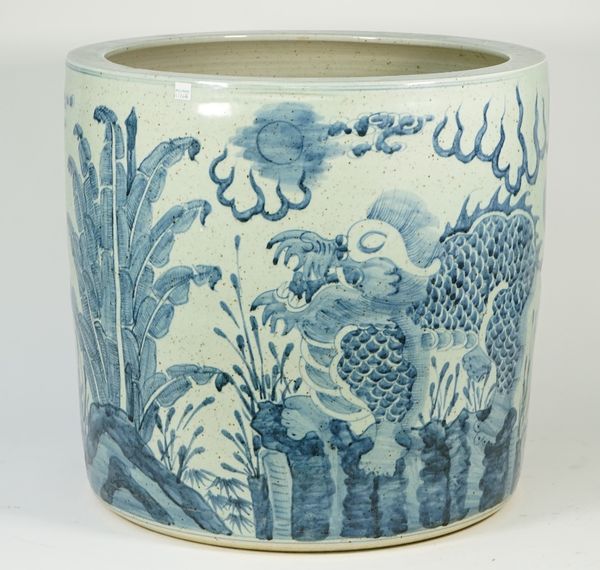 A large Chinese blue and white pottery jardiniere decorated with temple dogs against a landscape, 49cm high x 51cm diameter.