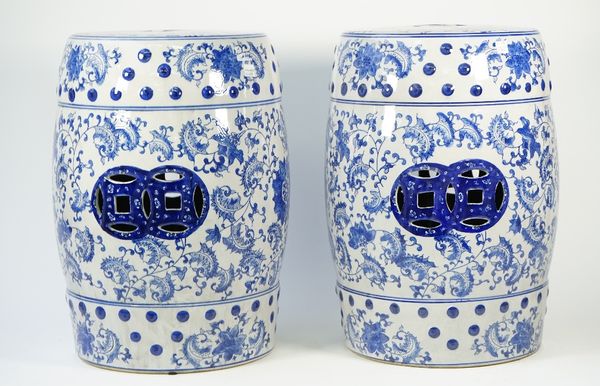 A pair of modern Chinese style blue and white porcelain garden seats, each foliate decorated against a pierced barrel form ground, 46cm high, (2).