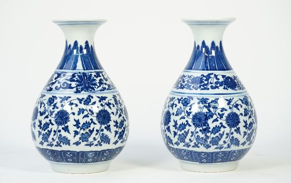 A pair of modern Chinese style blue and white porcelain vases, each foliate decorated against a baluster ground, printed mark to base, 21.5cm high, (2