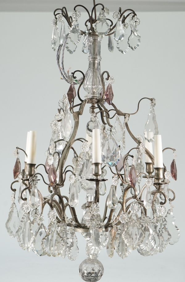 A Victorian style metal and glass mounted six light chandelier hung with shaped clear and amethyst coloured glass drops over a graduated frame, 75cm h