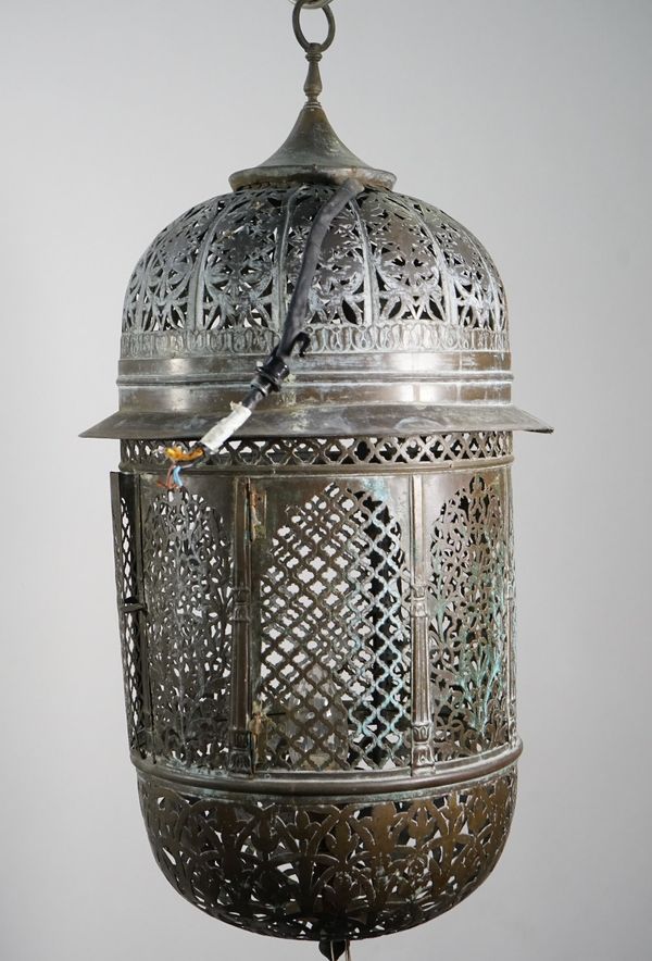 A pierced brass wall lantern, early 20th century, of Moroccan style with domed top and bottom, hinged door to the centre and an internal single light