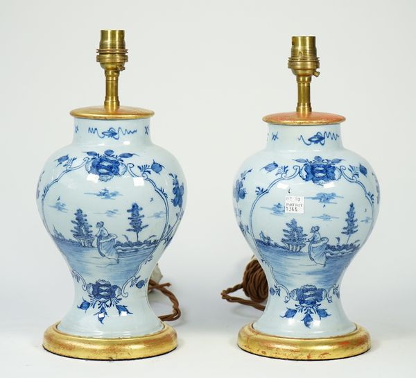 A pair of Dutch Delft blue table lamp vases, each decorated with a female figure in a landscape against a baluster ground with giltwood mounts, 25cm h