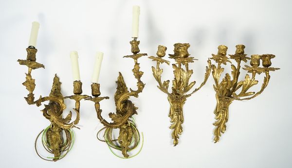 A pair of rococo style gilt bronze two branch wall appliques, 19th century, with foliate cast arms, 43cm high and another similar brass pair of two br