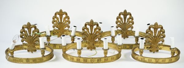 A set of three 19th century bronze four light wall appliques, of oval banded form with a foliate cast back pate, 25cm high, and two matching two branc