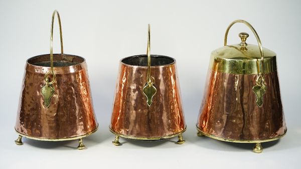 A Victorian copper and brass mounted coal bin with lid and swing over handle raised on three brass feet, 36cm high and two matching coal bins, lacking