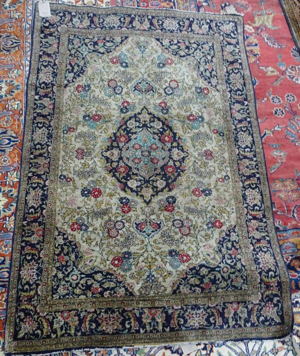 A Turkish silk rug, the madder field with a black and ivory medallion, orange spandrels, all with floral sprays, a black complementary border, 200cm x