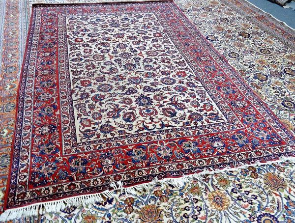 An Esfahan carpet, Persian, the ivory field with an allover palmette and floral vine design, complementary madder palmette border, 310cm x 222cm.