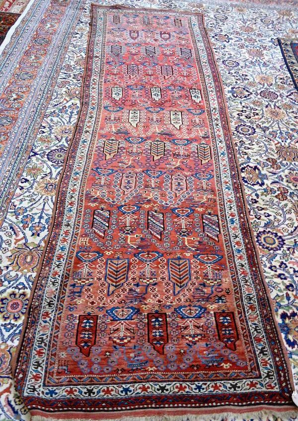 A Bashir runner, the madder field with rows of boteh's and other minor floral sprays, minor ivory flower border, 343cm x 102cm.