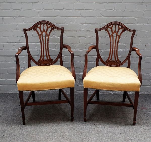 A pair of George III mahogany shield back open armchairs on tapering square supports, 60cm wide x 96cm high.