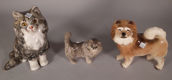 A 20th century glazed ceramic model of a cat, 24cm high, a smaller Doulton cat, 13cm high and a ceramic dog, 19cm high, (3). S1T