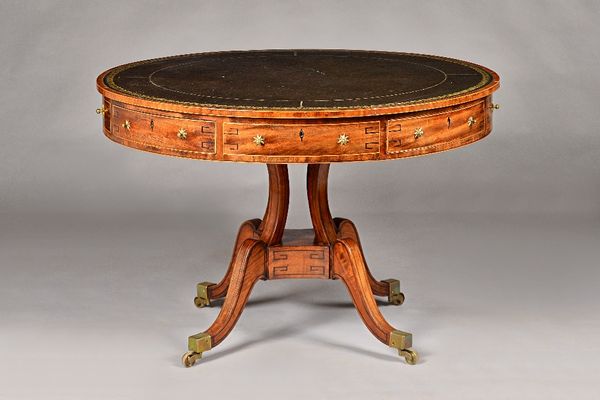 A George III ebony strung mahogany drum table, the leather inset circular top over four true and four dummy frieze drawers, on open column and four do