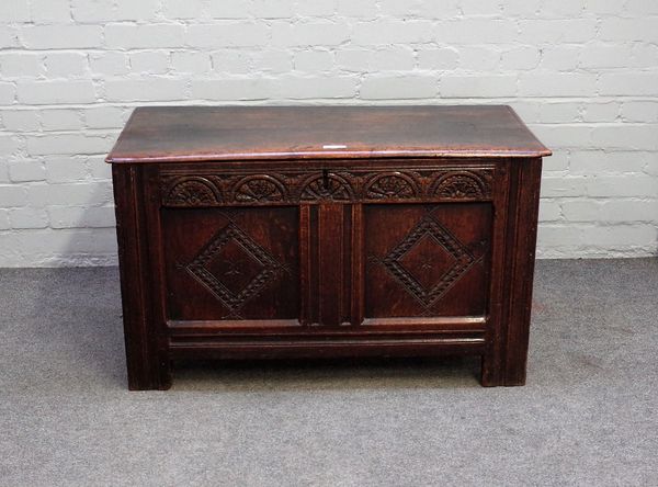 A 17th century oak coffer, with twin plank lid and carved double panel front, 99cm wide x 68cm high.