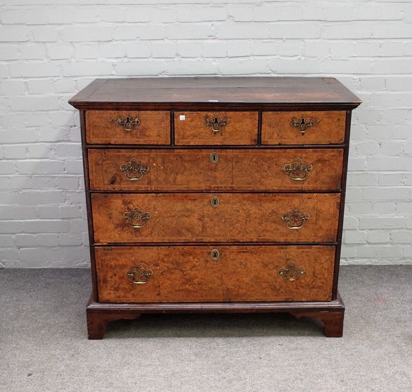 A George I feather banded burr walnut chest with three short over three long graduated drawers, on bracket feet, 106cm wide x 98cm high.