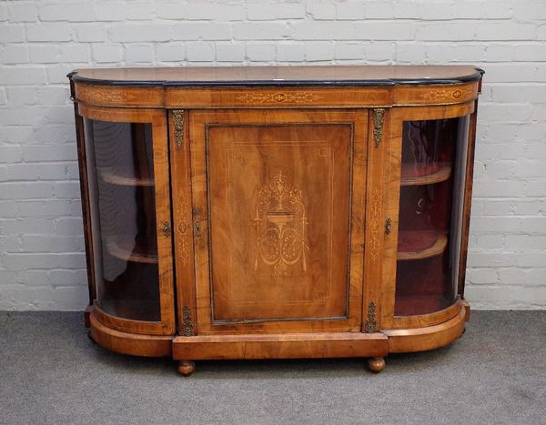 A Victorian gilt metal mounted inlaid walnut credenza, with central panel door, flanked by glazed rounded cupboards, 148cm wide x 106cm high.