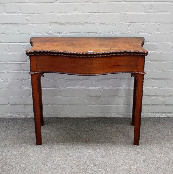 A George III mahogany tea table, the carved serpentine foldover top on turned block supports, 81cm wide x 73cm high.