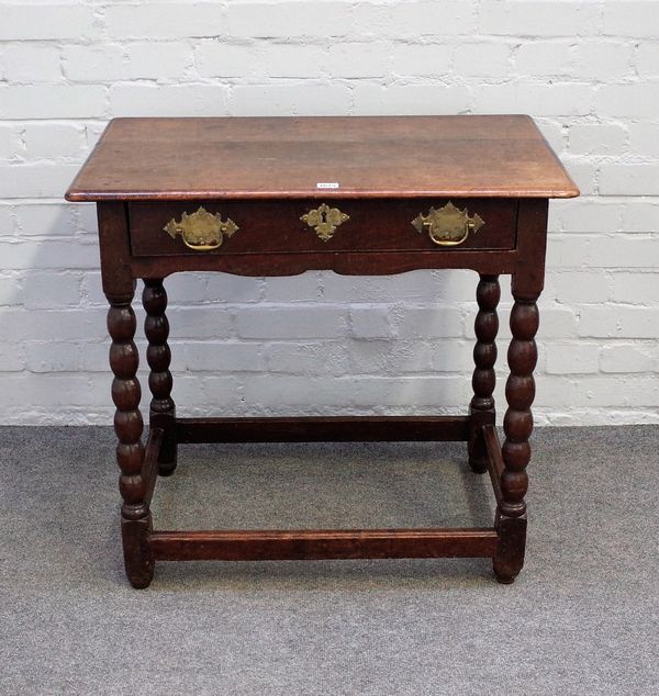 A 17th century oak side table with single frieze drawer on bobbin turned supports, united by perimeter stretcher, 77cm wide 72cm high.