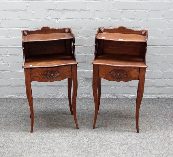 A pair of French oak serpentine fronted two tier single drawer bedside tables, on cabriole supports, 40cm wide x 75cm high.