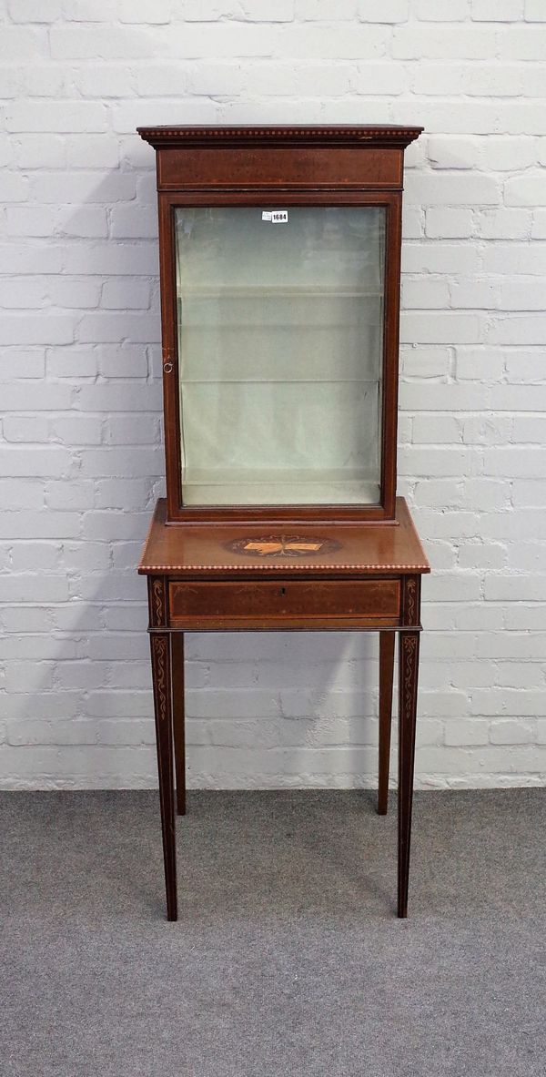 An Edwardian marquetry inlaid mahogany display cabinet on stand, the single glazed door over single drawer on tapering square supports, 57cm wide x 16