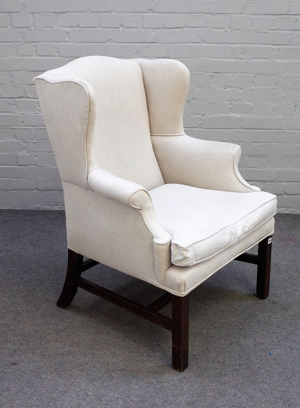 A George II style wingback armchair in cream upholstery, on block supports, 80cm wide x 103cm high.