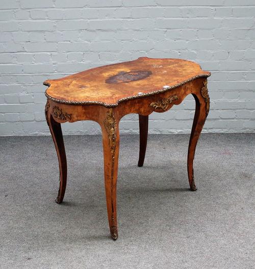 A Victorian gilt metal mounted marquetry inlaid figured walnut centre table, with shaped oval top, on cabriole supports, 101cm wide x 76cm high.