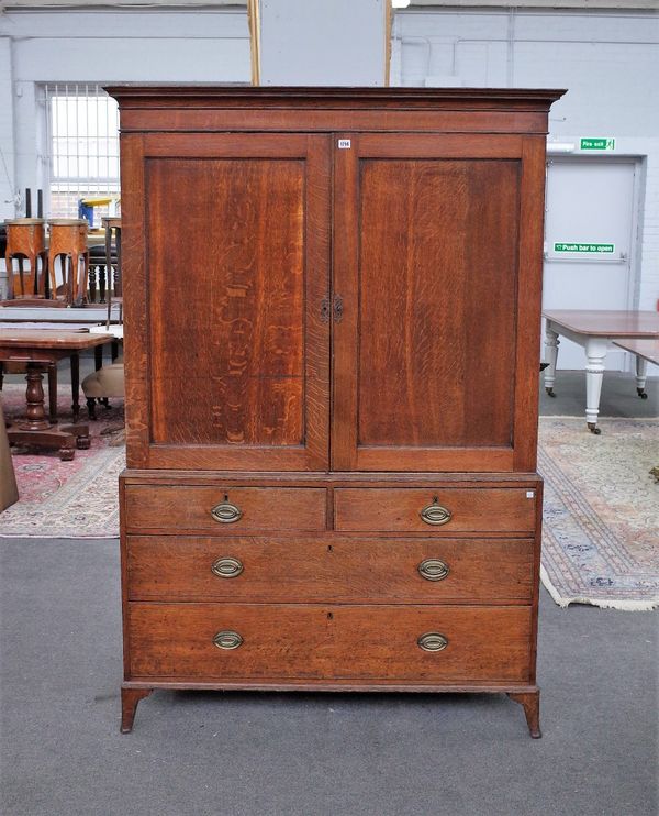 A George III oak linen press with pair of panel doors over two short and two long graduated drawers on splayed bracket feet, 123cm wide x 182cm high.