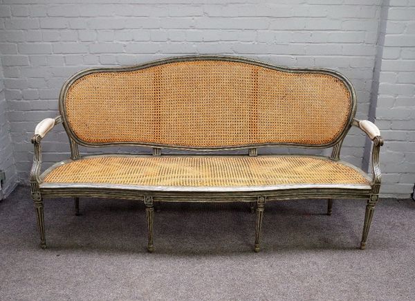 A Louis XVI style open arm sofa with distressed green/ grey painted frame and serpentine seat, on tapering fluted supports, 188cm wide x 100cm high.