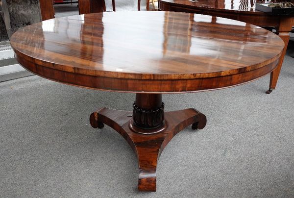 A William IV rosewood centre table, the circular snap top on lappet carved column and triform platform, 131cm diameter x 74cm high.