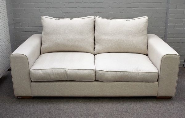 Heals; a Moretta medium seat sofa upholstered in cream fabric on block feet, 195cm wide x 75cm high.