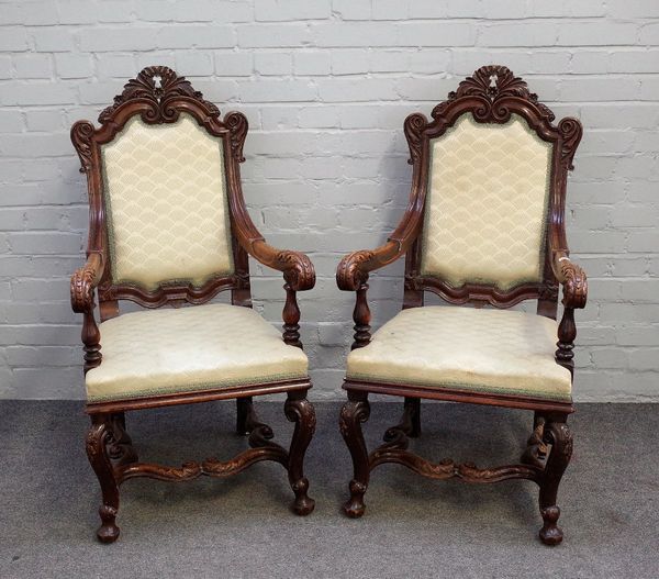 A pair of 17th century style carved oak open armchairs, with acanthus carved crest and scroll supports, united by 'H' frame stretcher, 59cm wide x 112