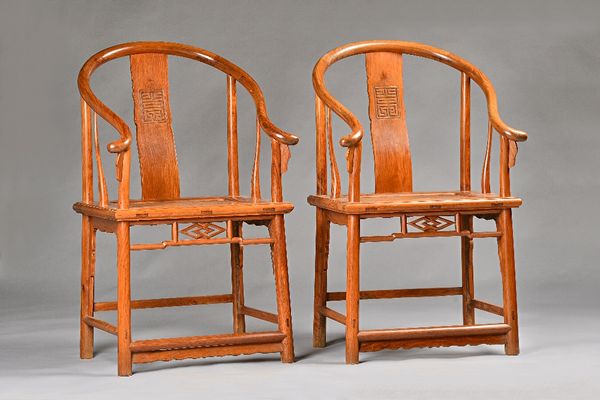 A pair of early 20th century Chinese huanghuali horseshoe back armchairs, with solid seats, on turned supports, 61cm wide x 104cm high.